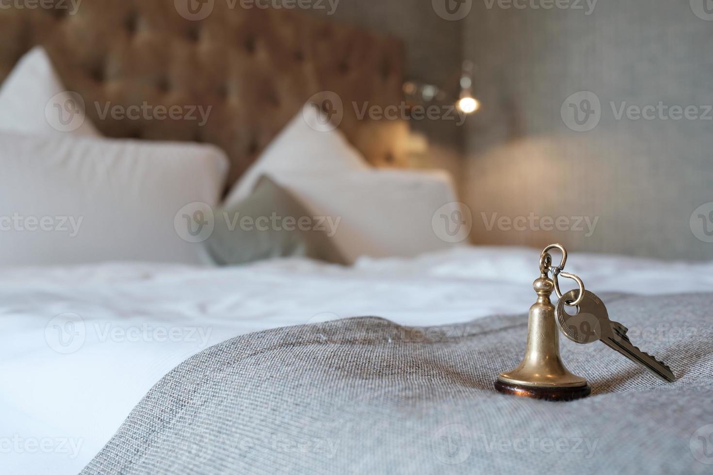 Key with a key fob from the hotel room lies on the bed. photo