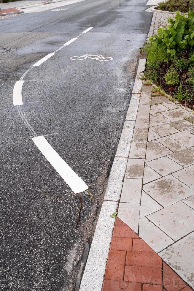 Signs on an asphalt road allowing cycling. Bike lane with symbols and dotted line. Concept of safe movement. photo