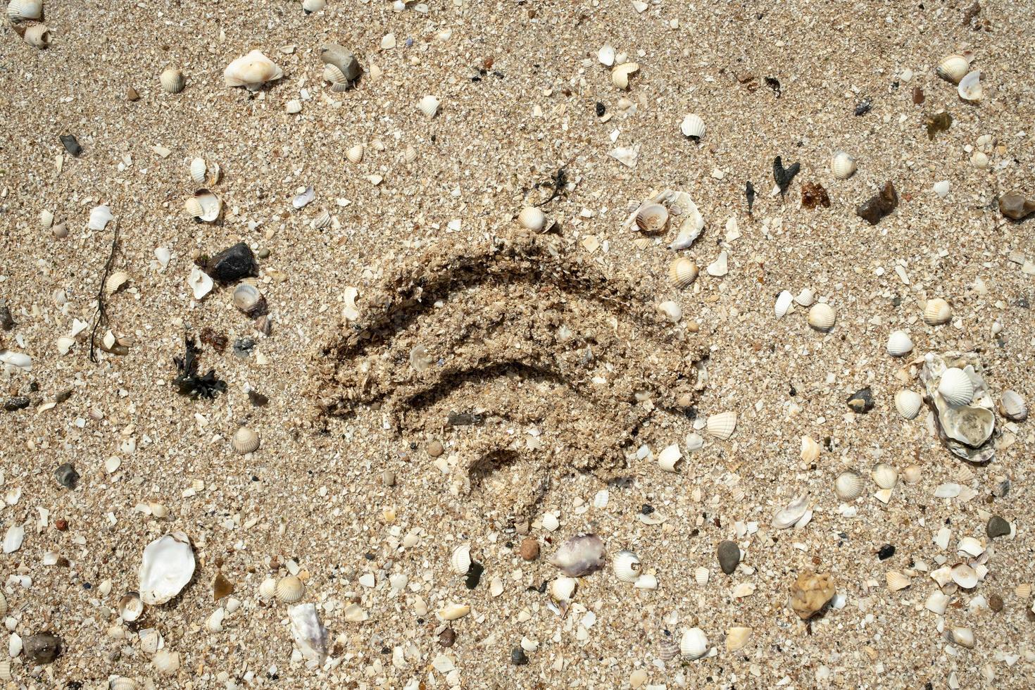WiFi sign is drawn in the sand, on the seashore, on a summer day. Top view. photo
