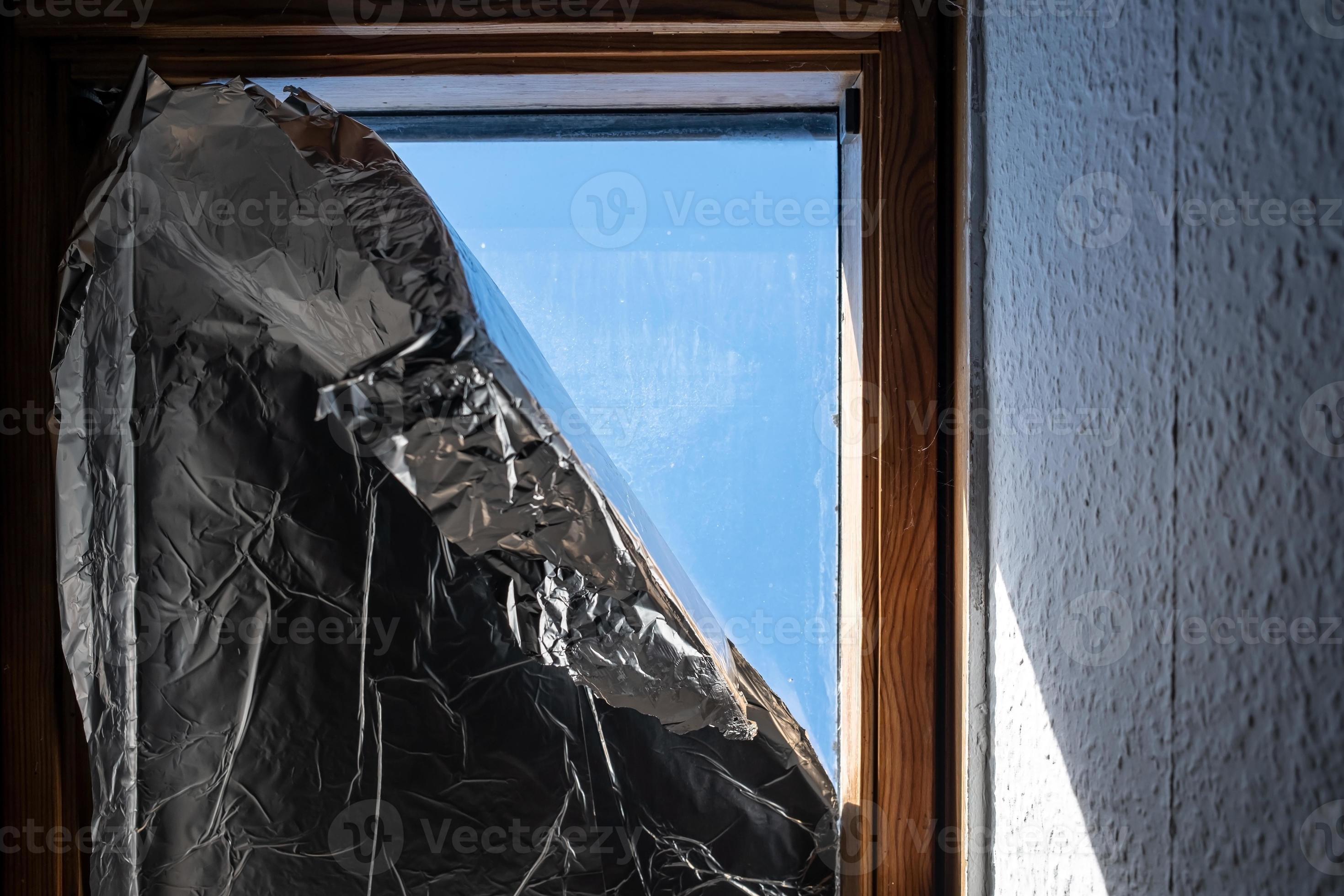Window covered with foil to prevent sunlight from entering house during