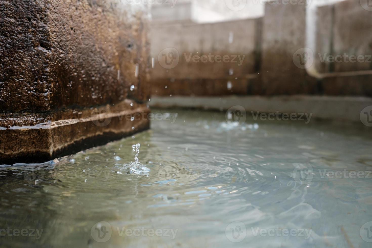 Water drops in an old stone European drying fountain photo