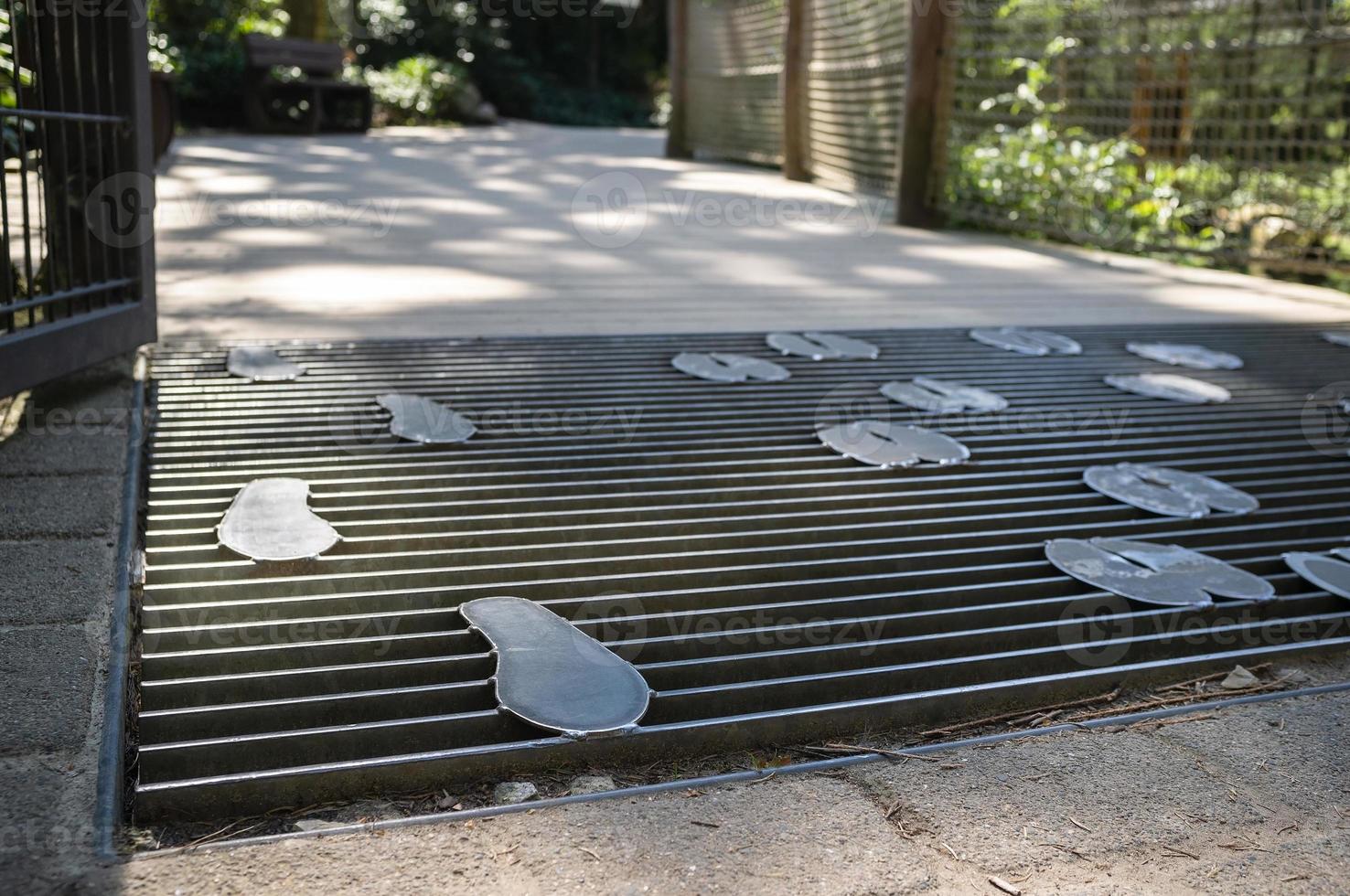 mesh bridge with metal footprints on a walkway in a petting zoo photo