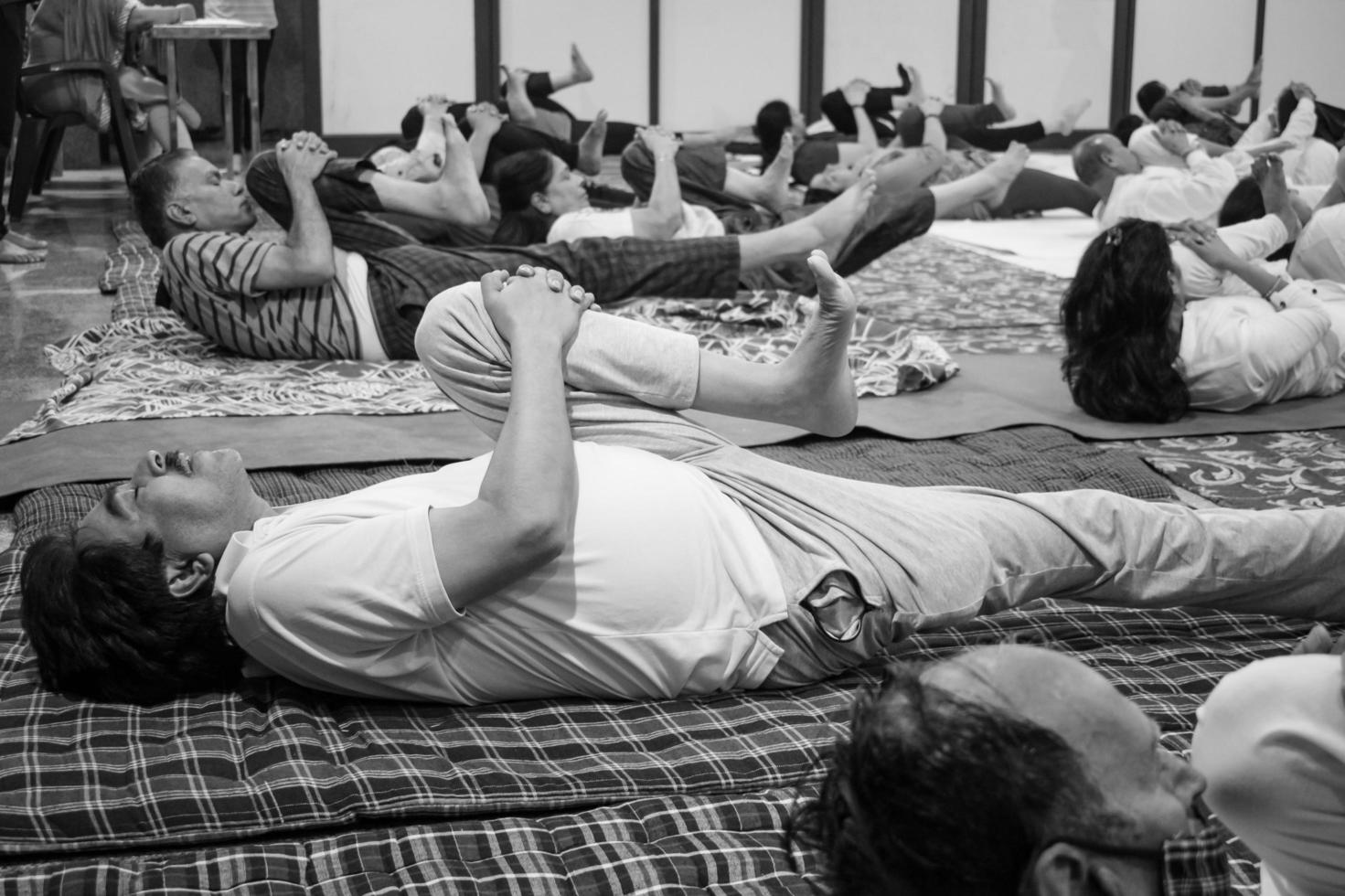 Delhi, India, June 19 2022-Group Yoga exercise session for people of different age groups in Balaji Temple,Vivek Vihar, International Yoga Day, Big group of adults attending yoga class-Black and White photo