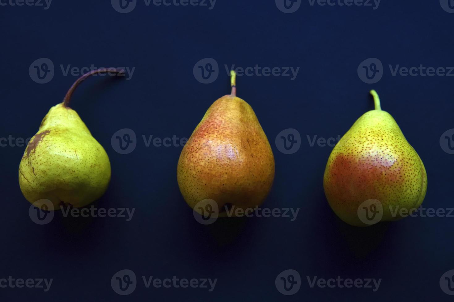 Red and green pears on a black background. Pears in a package from the store. Beautiful fruits of pears. photo