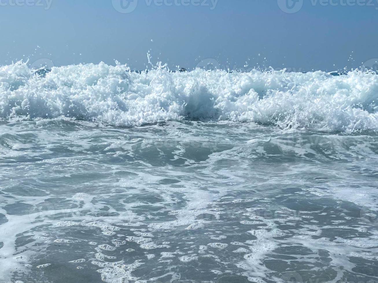 hermoso mar con olas salpicando cálidas y brillantes aguas azules en un cálido resort tropical oriental del sur. fondo, textura foto