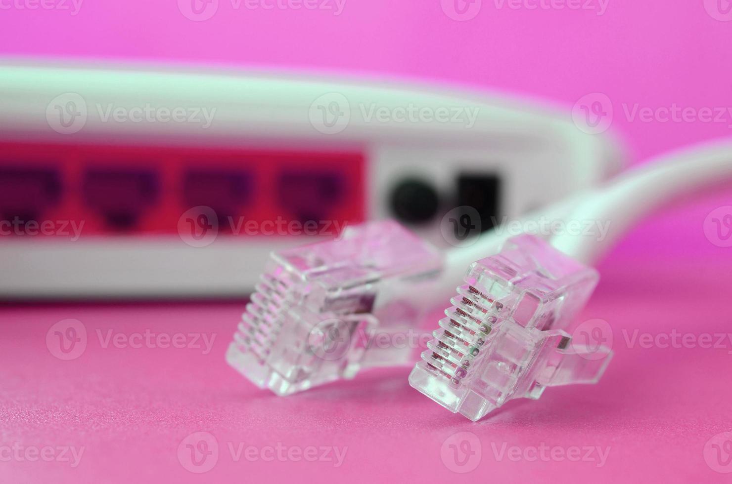 Internet router and Internet cable plugs lie on a bright pink background. Items required for Internet photo
