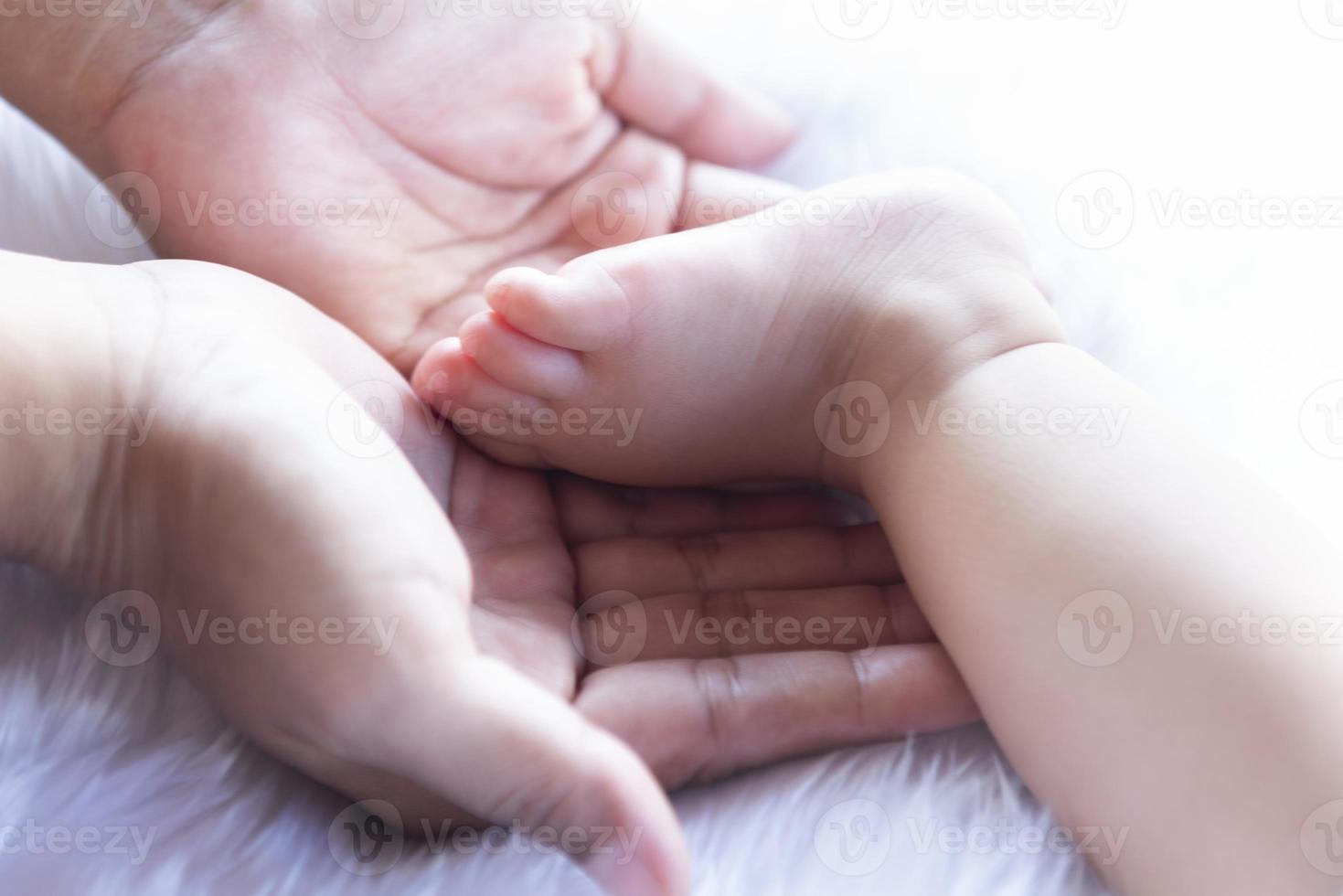 Small child's feet on white bedding. photo