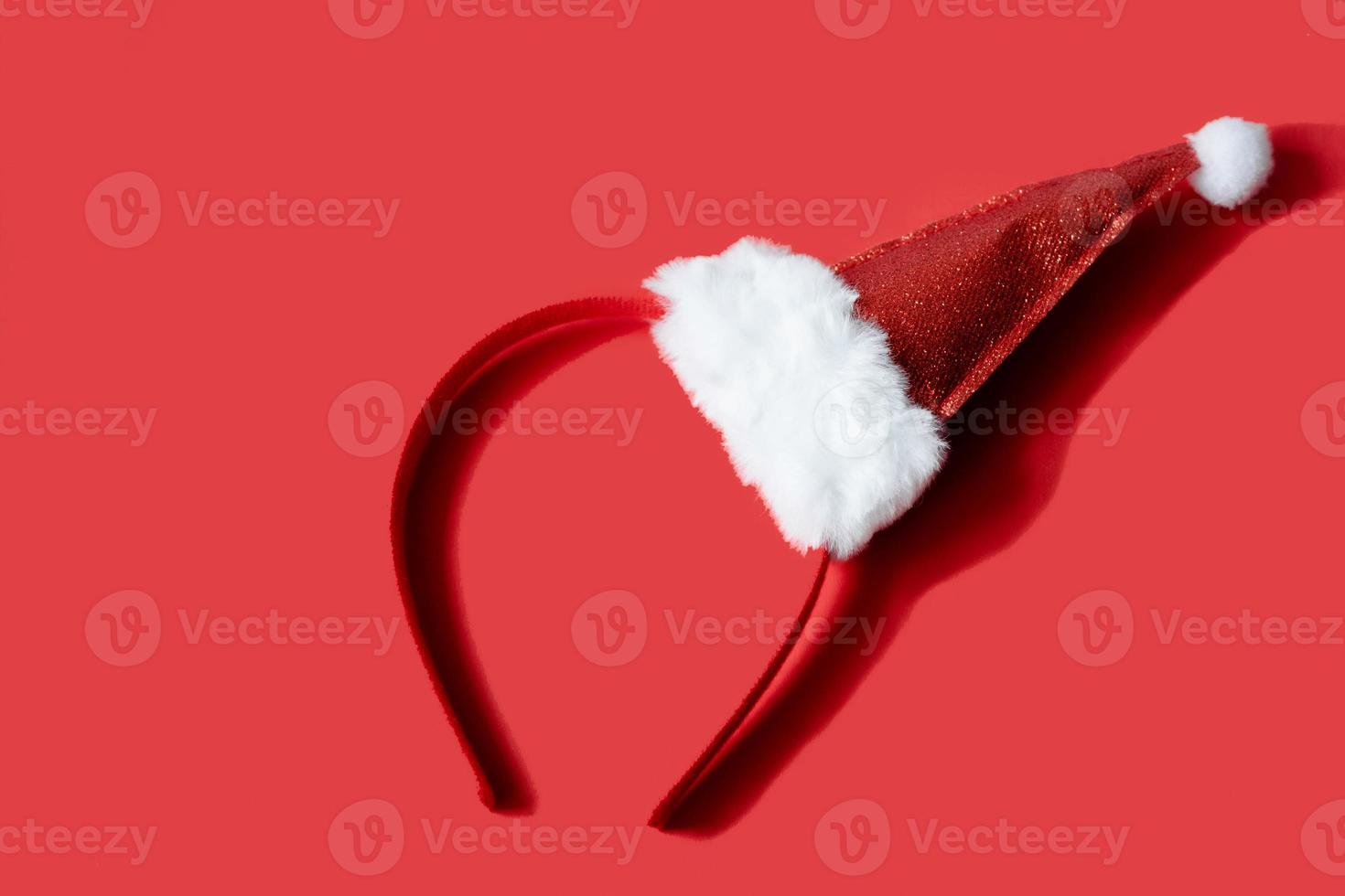New Year's red santa hat, headband, on a red background. Minimalistic and stylish photography with a christmas theme photo