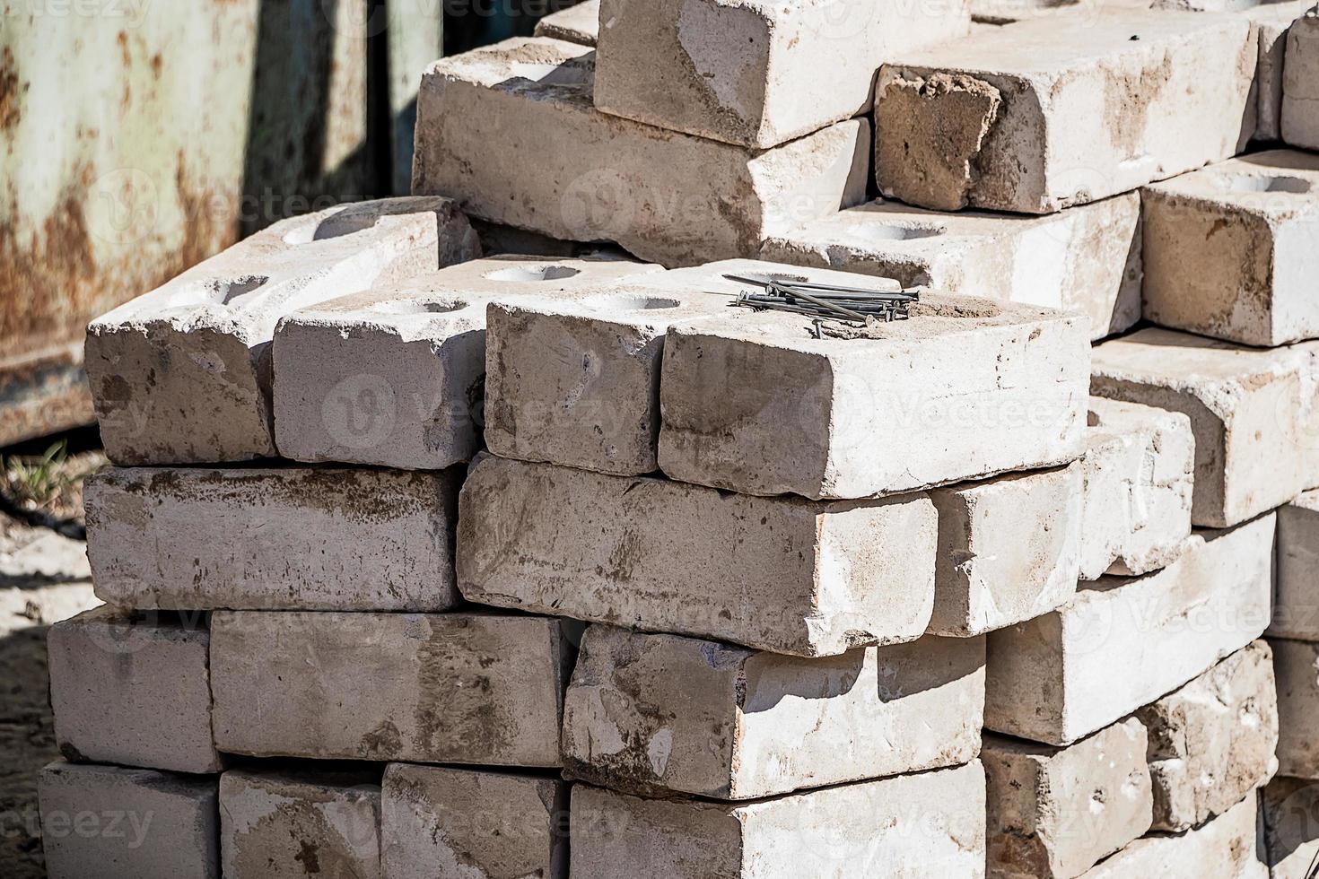 Building materials on site. Construction nails on stack of white bricks. photo