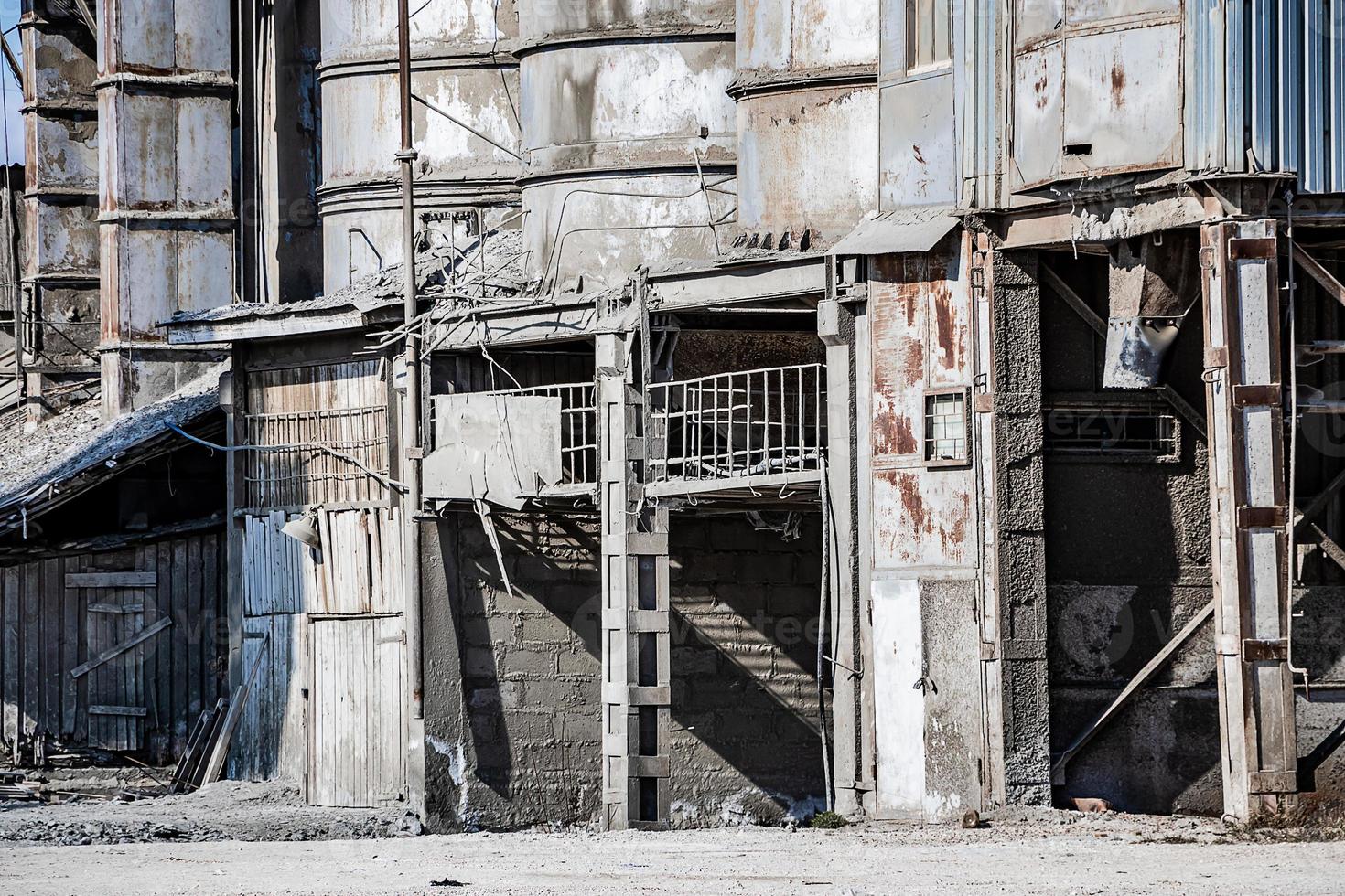 Old destroyed construction site. Rusty scaffolding and construction equipment. photo