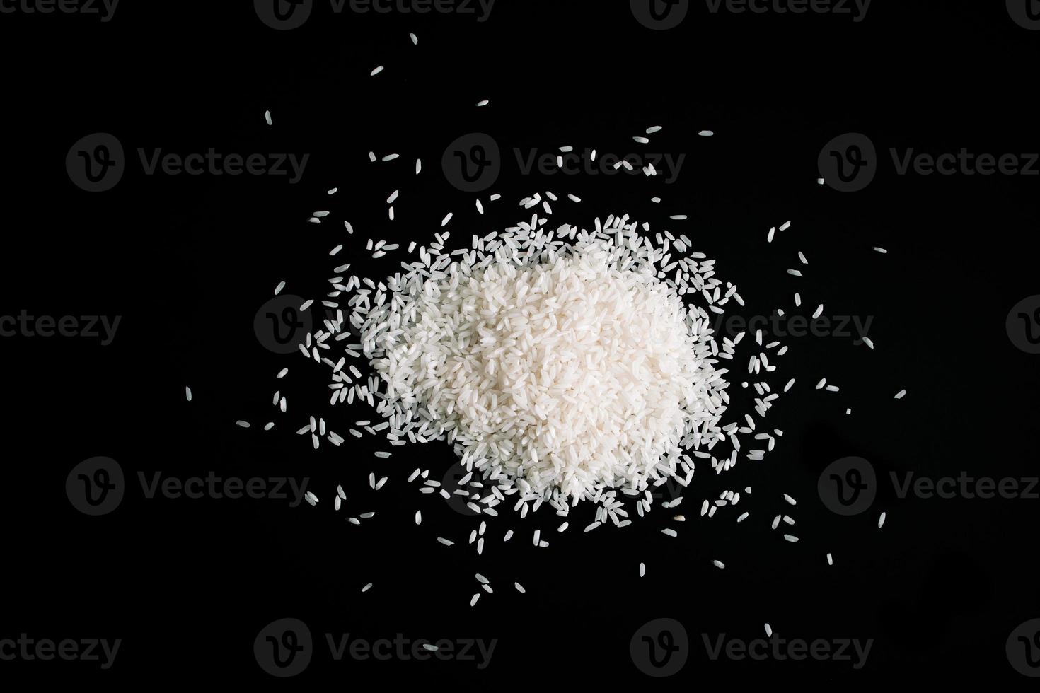 Pile of uncooked white rice on black background. Natural organic vegan food. photo