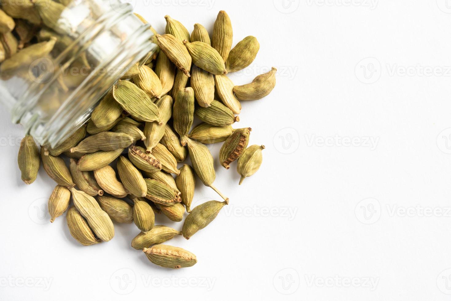 Green Cardamom Pods Spilled from a Jar photo