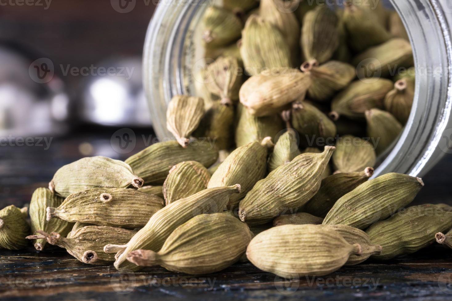 Green Cardamom Pods Spilled from a Jar photo