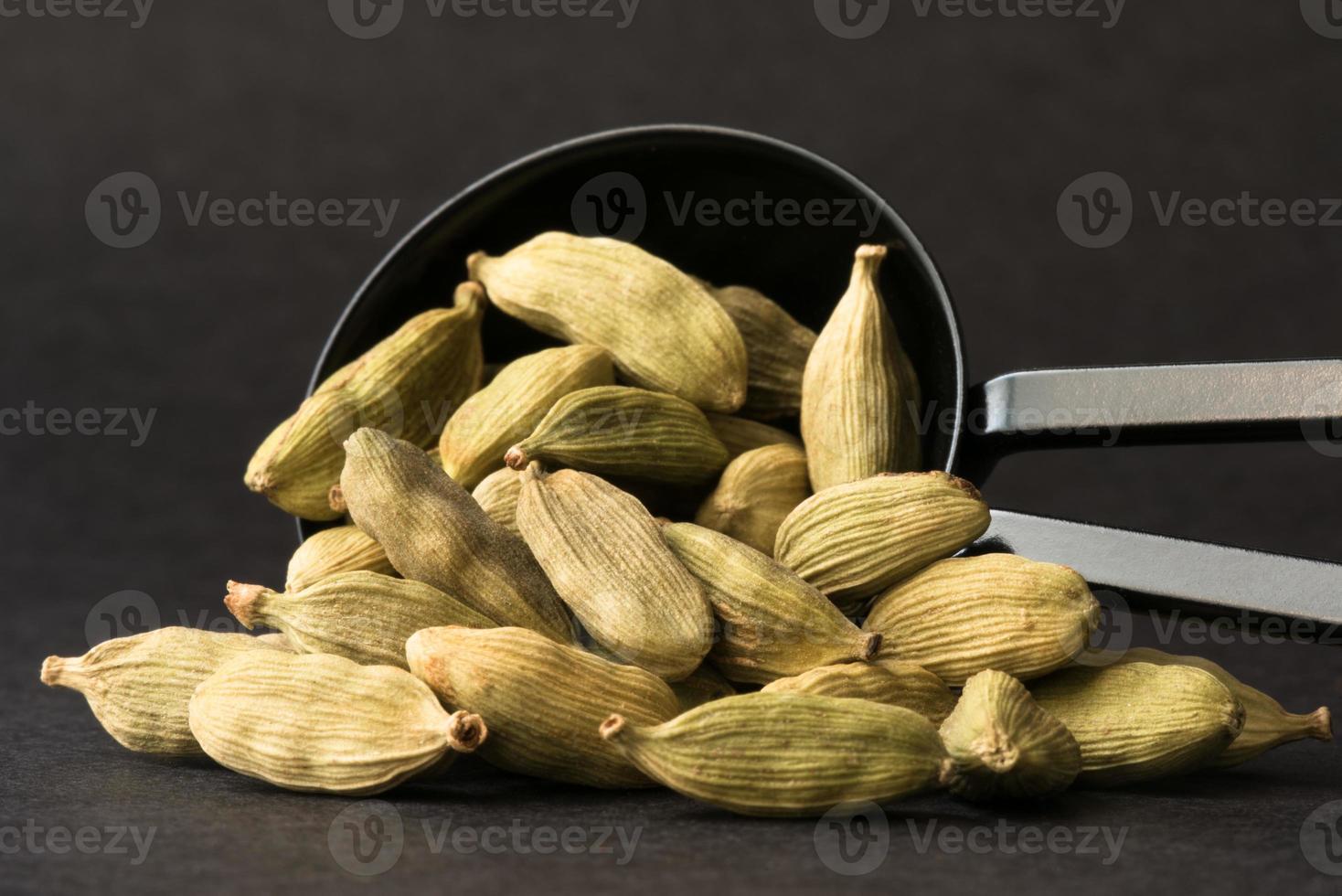 Green Cardamom Pods Spilled from a Teaspoon photo