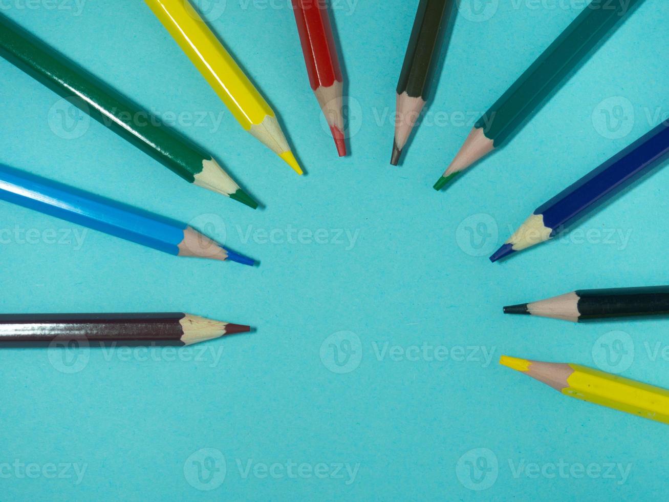 lápices de madera de colores sobre papel de colores. lápices afilados. herramienta de dibujo accesorios para la creatividad. foto