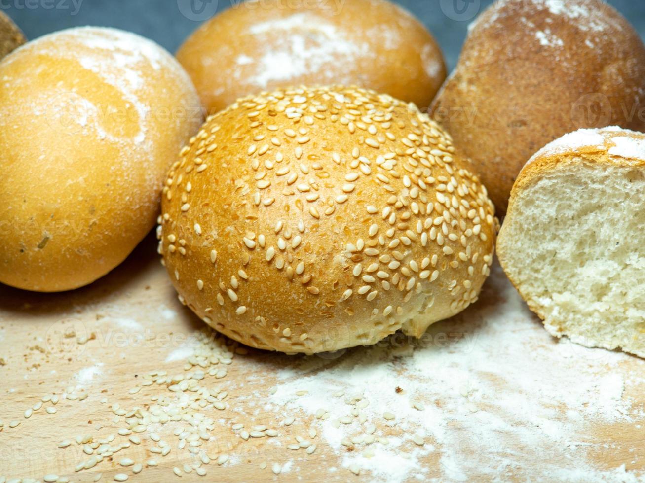 Bakery products.  Buns on a cutting board. Rye and wheat buns. Products from premium wheat flour and rye flour. photo