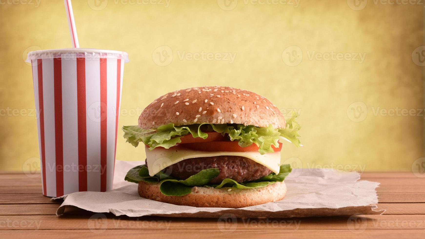 hamburguesa de ternera con refresco en la mesa foto