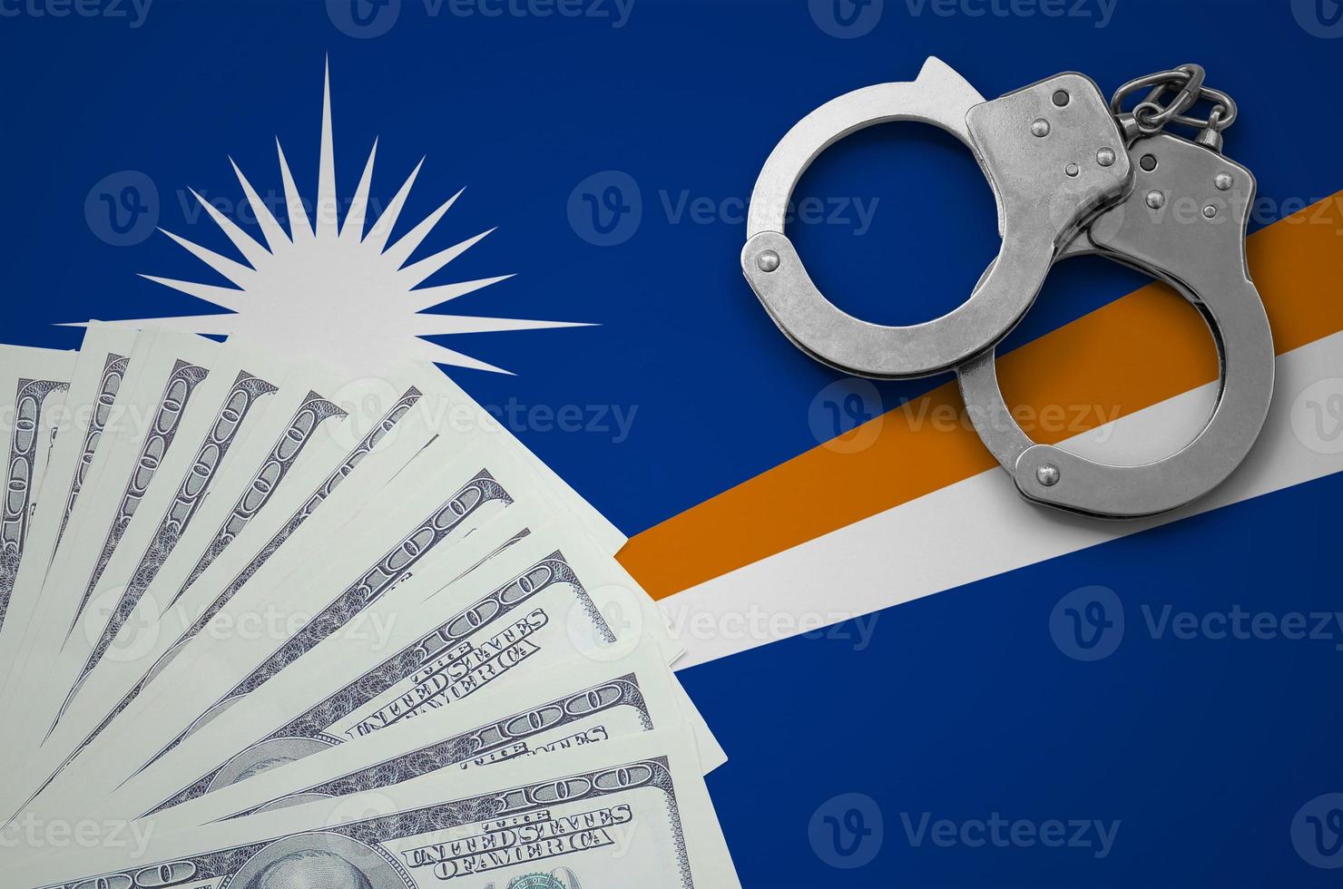 Marshall Islands flag with handcuffs and a bundle of dollars. The concept of illegal banking operations in US currency photo