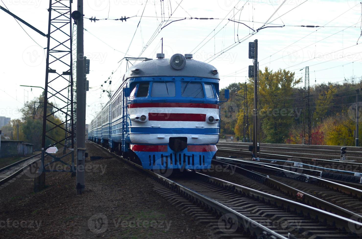 Old soviet electric train with outdated design moving by rail photo