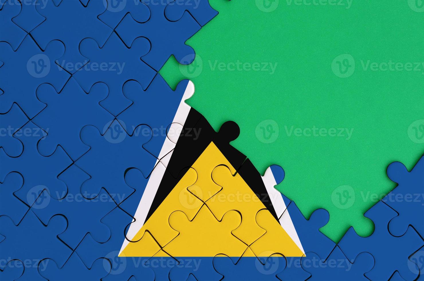 Saint Lucia flag is depicted on a completed jigsaw puzzle with free green copy space on the right side photo