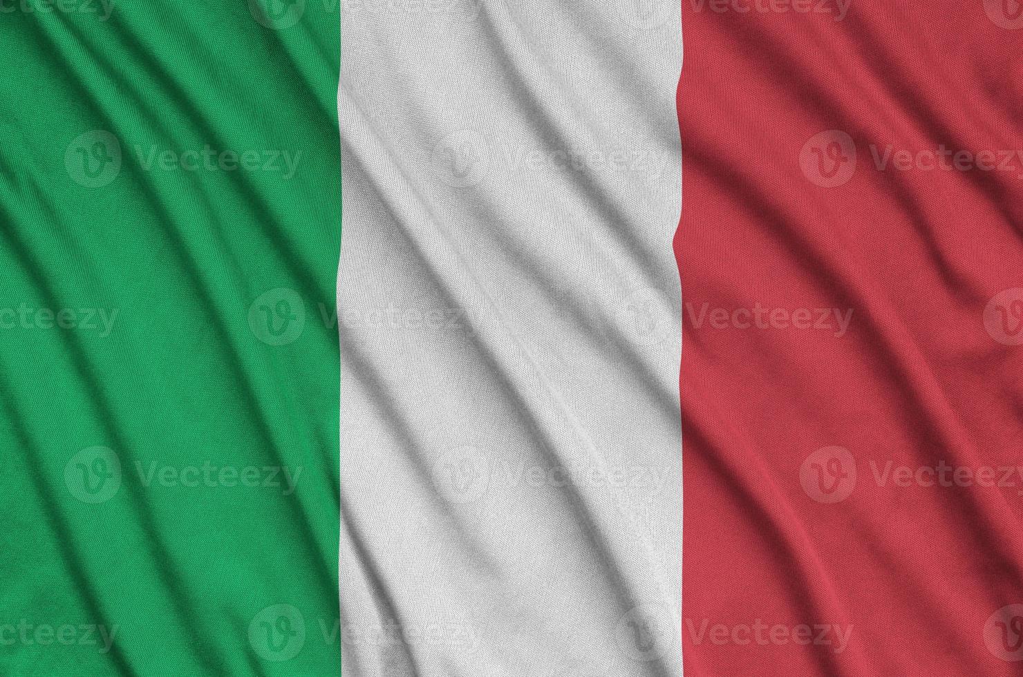Italy flag is depicted on a sports cloth fabric with many folds. Sport team banner photo
