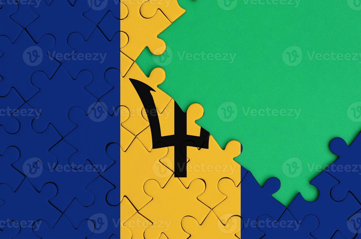 Barbados flag is depicted on a completed jigsaw puzzle with free green copy space on the right side photo