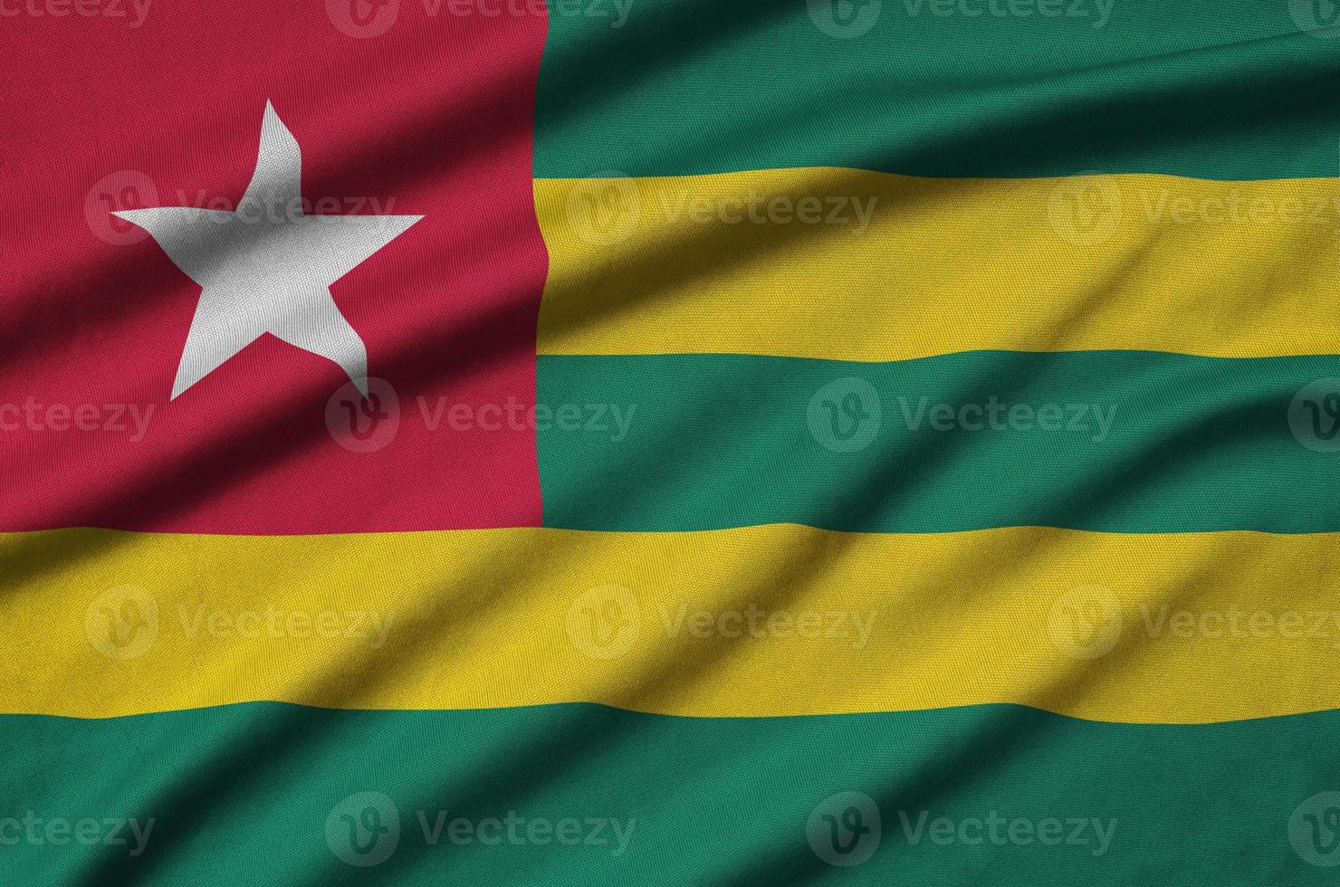 Togo flag is depicted on a sports cloth fabric with many folds. Sport team banner photo