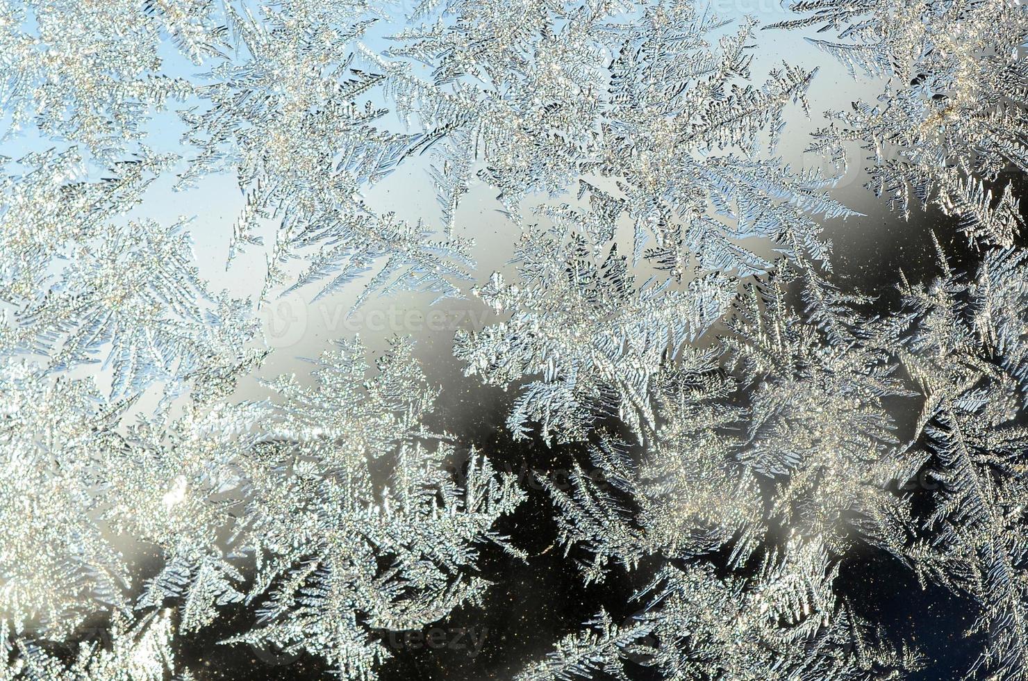 Snowflakes frost rime macro on window glass pane photo