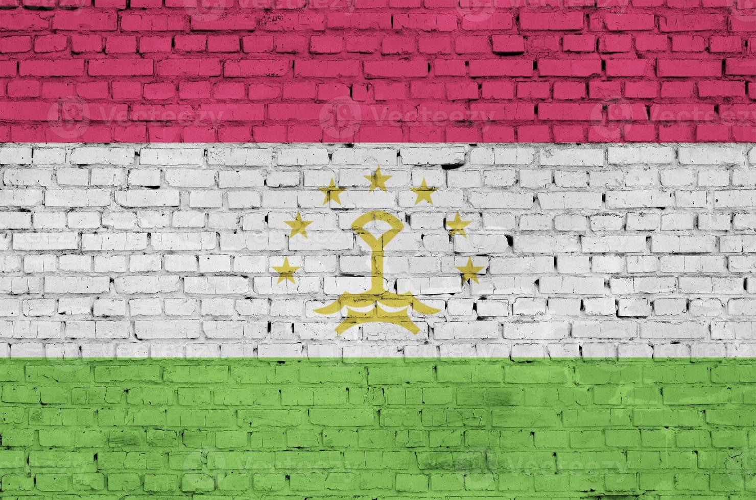 Tajikistan flag is painted onto an old brick wall photo