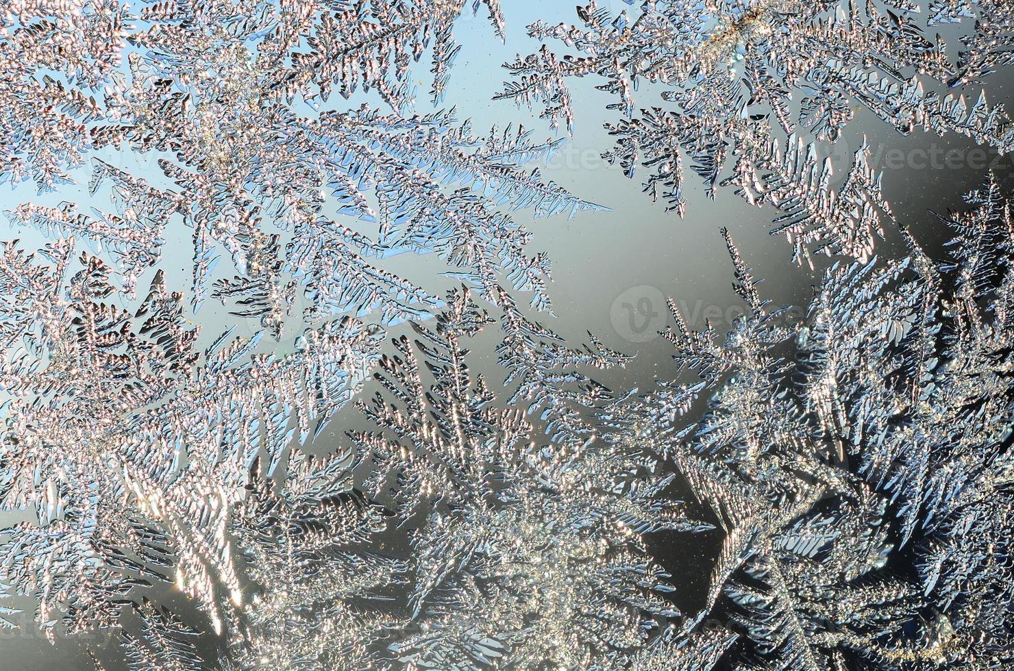Snowflakes frost rime macro on window glass pane photo