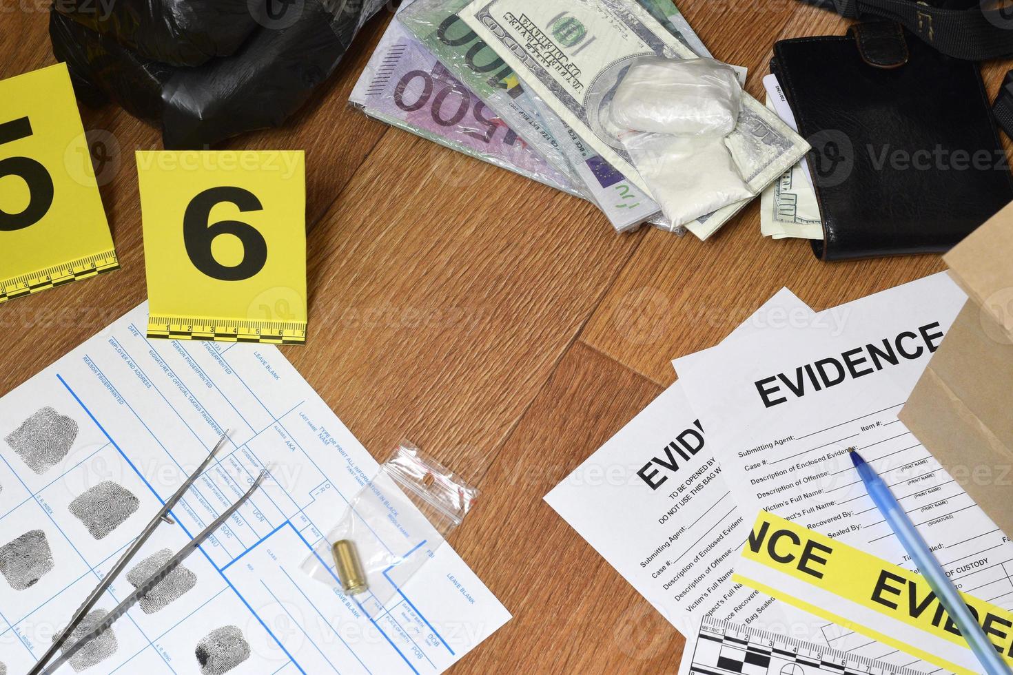 etiquetas de cadena de custodia de evidencia y bolsa de papel marrón con huellas dactilares la tarjeta del solicitante se encuentra contra grandes paquetes de heroína y paquetes de billetes de dinero como evidencia en el proceso de investigación de la escena del crimen foto