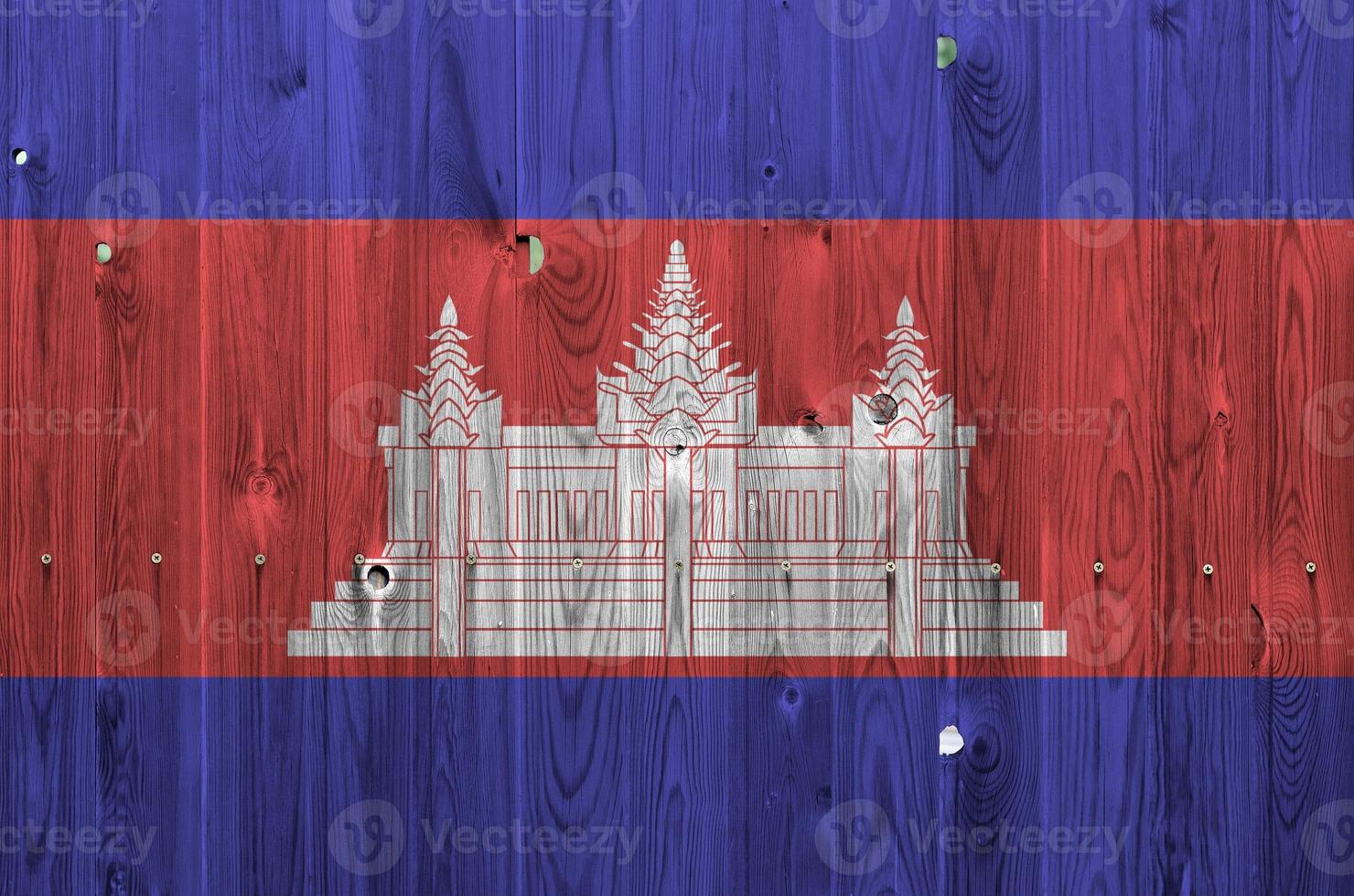 Cambodia flag depicted in bright paint colors on old wooden wall. Textured banner on rough background photo