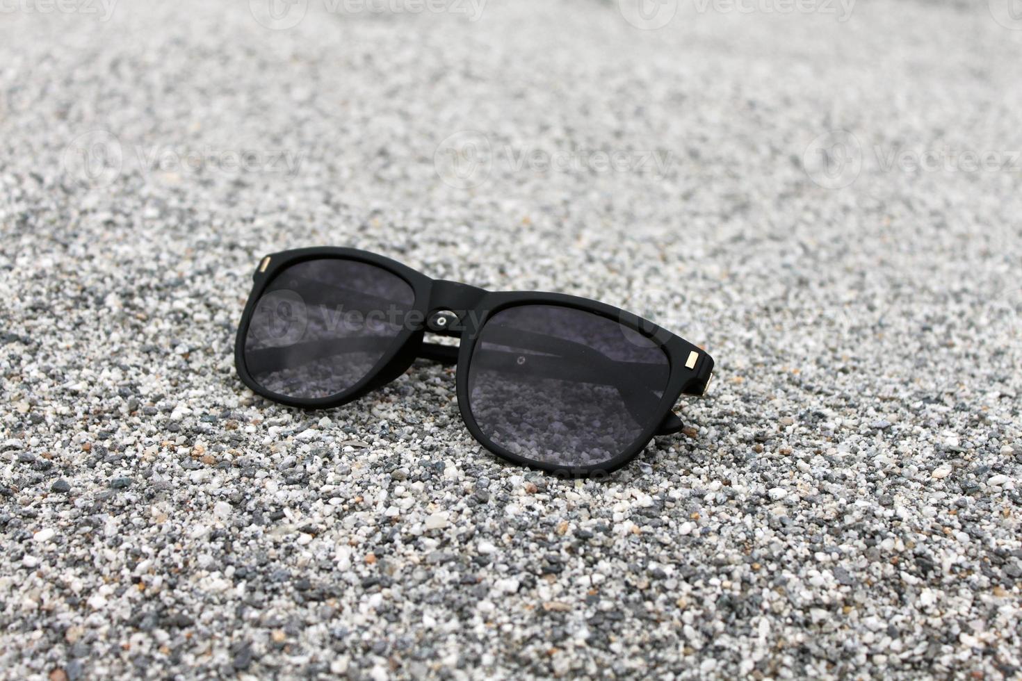 Sunglasses on Sand background Closeup photo