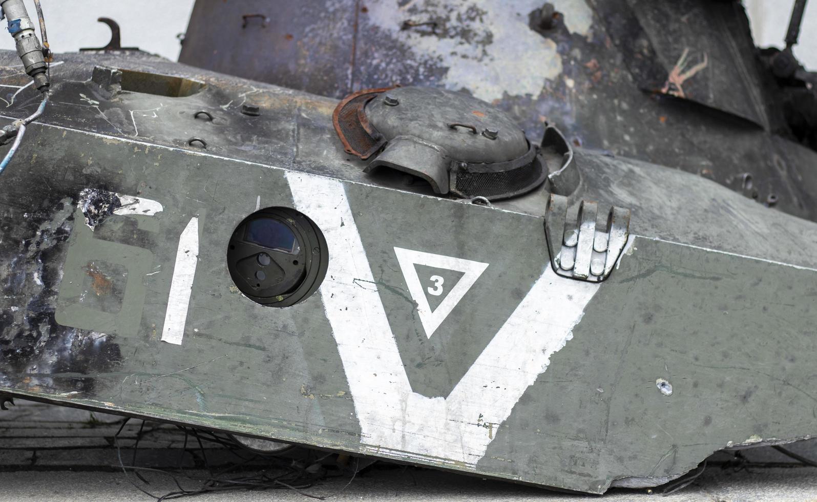 War in Ukraine. Destroyed tank with torn off turret. Broken and burned military tanks. Designation of a sign or symbol in white paint on the tank. Destroyed military equipment. War against Ukraine. photo