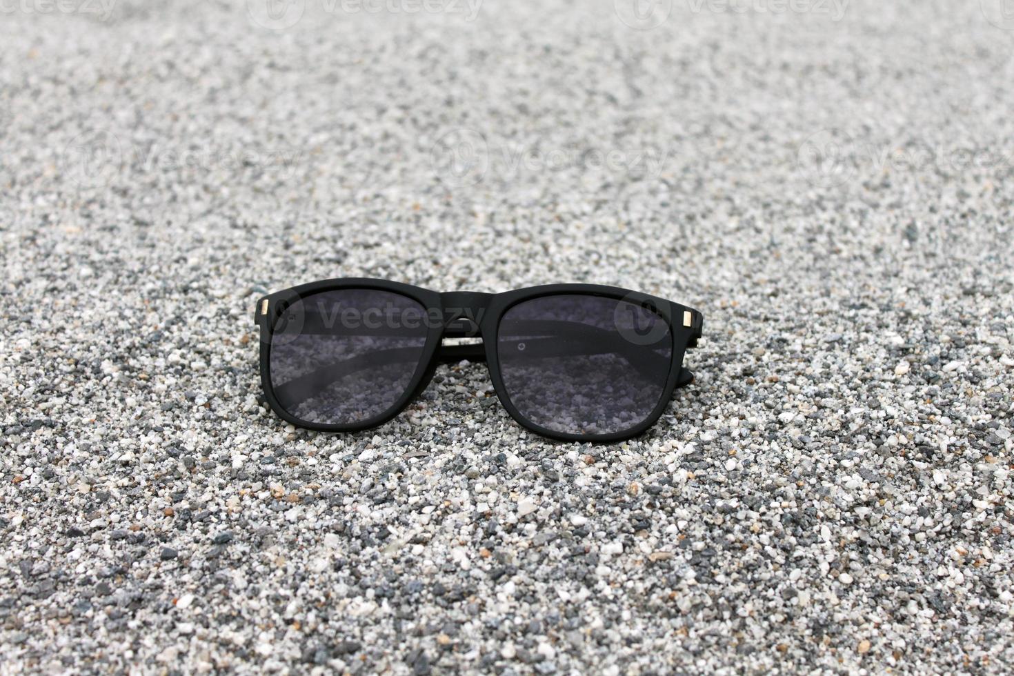 Sunglasses on Sand background Closeup photo