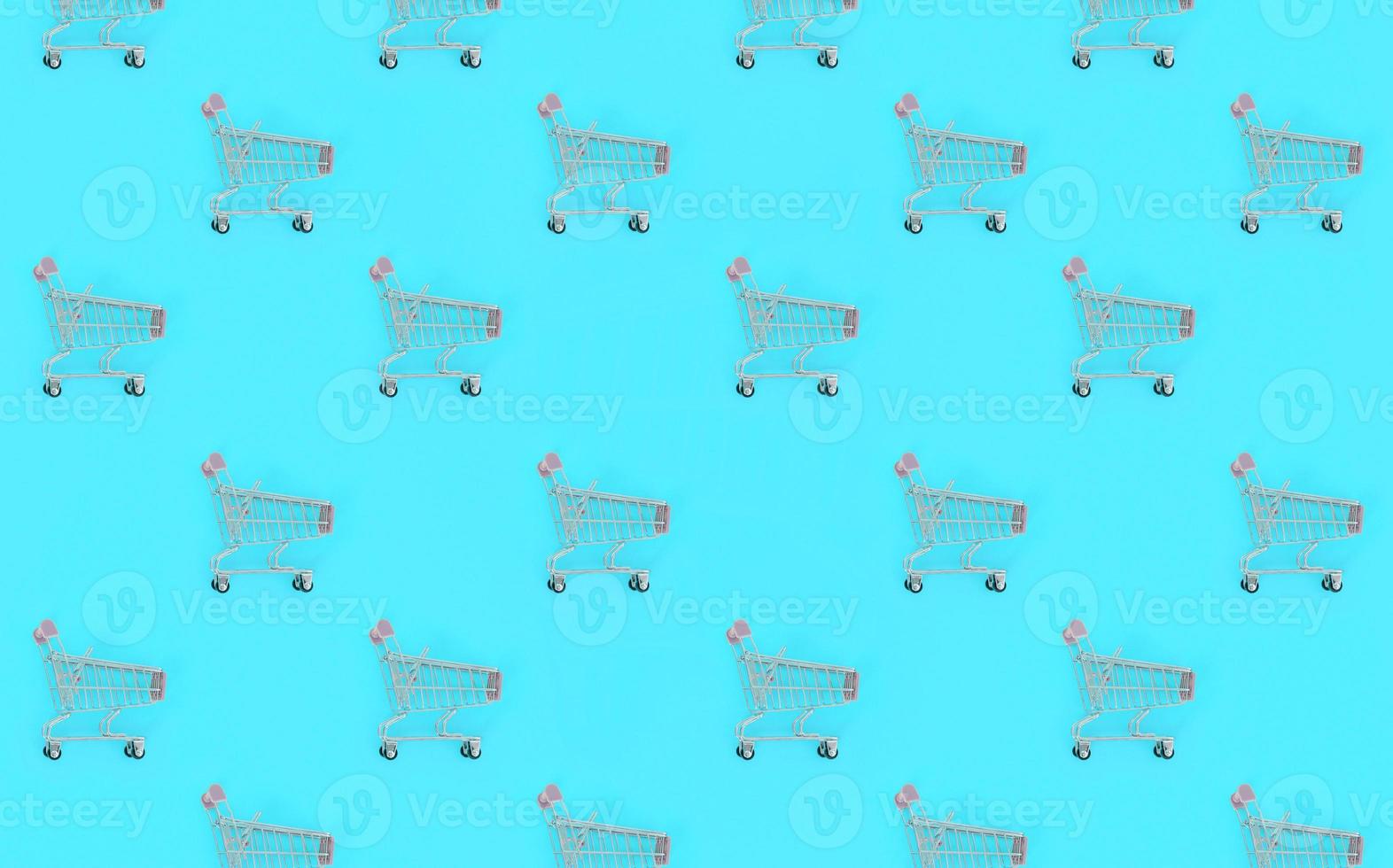 Shopping addiction, shopping lover or shopaholic concept. Many small empty shopping carts perform a pattern on a pastel colored paper background. Flat lay composition, top view photo