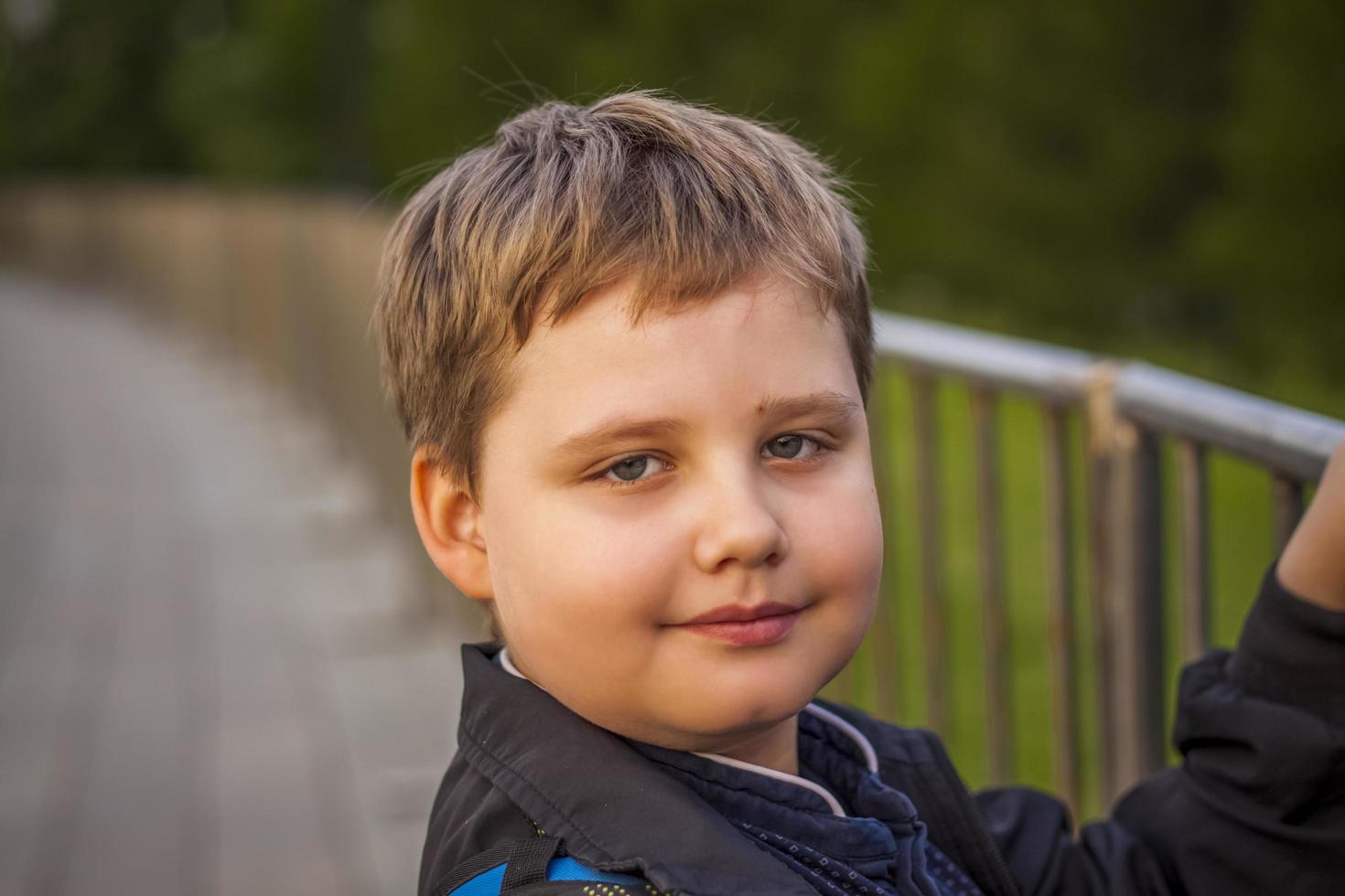 Portrait of a child, a boy against the backdrop of urban landscapes of skyscrapers and high-rise buildings in the open air. Children, Travel. Lifestyle in the city. Center, streets. photo