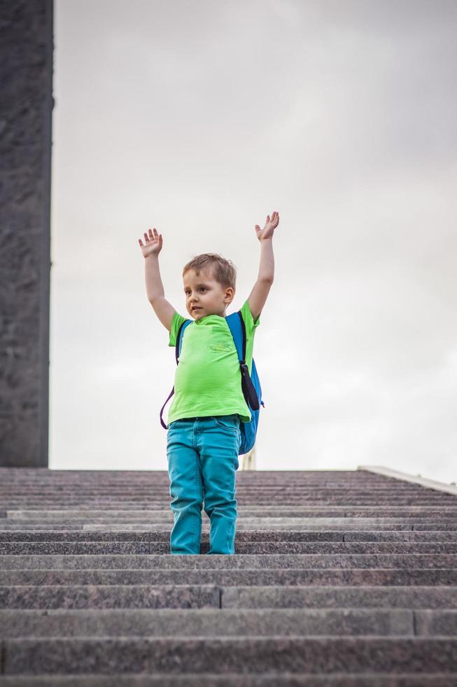 Portrait of a child, a boy against the backdrop of urban landscapes of skyscrapers and high-rise buildings in the open air. Children, Travel. Lifestyle in the city. Center, streets. photo