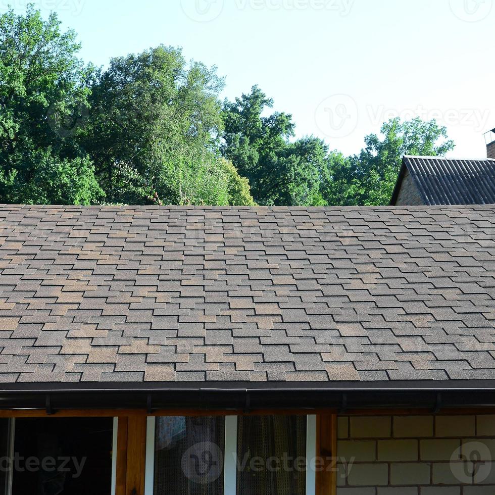 Modern roofing and decoration of chimneys. Flexible bitumen or slate shingles photo