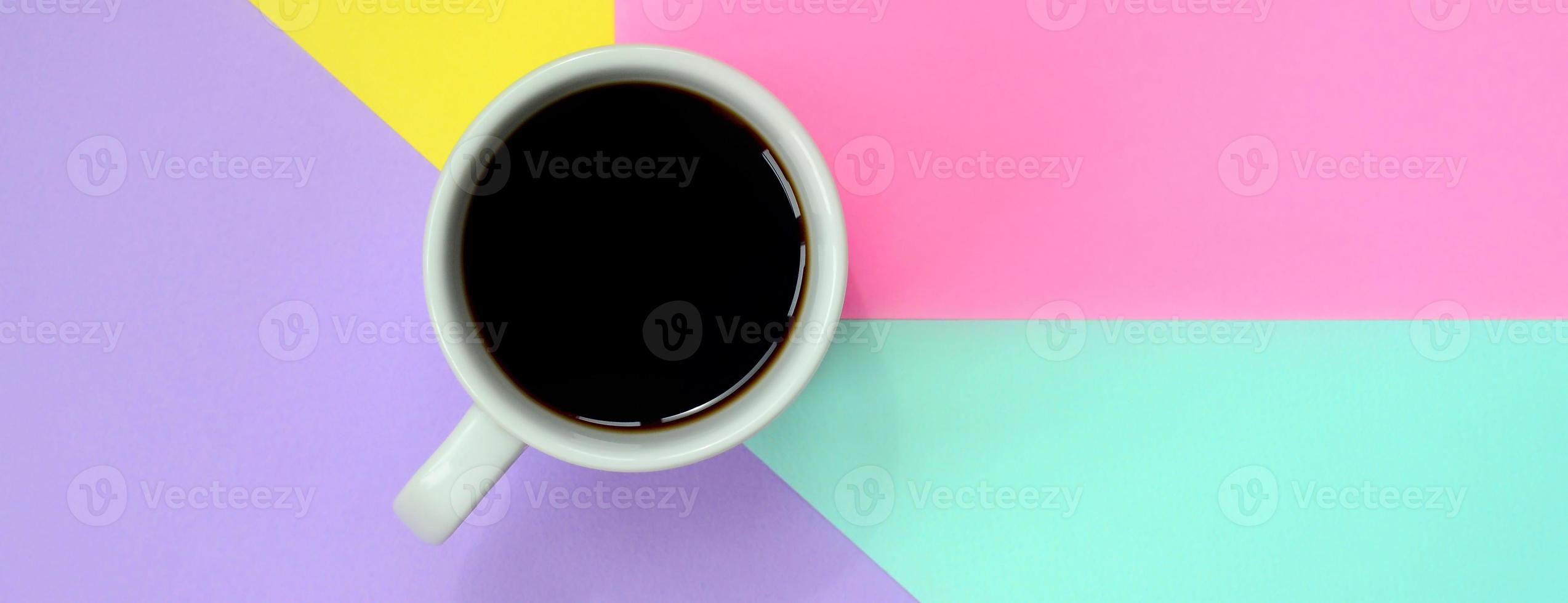 Small white coffee cup on texture background of fashion pastel blue, yellow, violet and pink colors paper in minimal concept photo