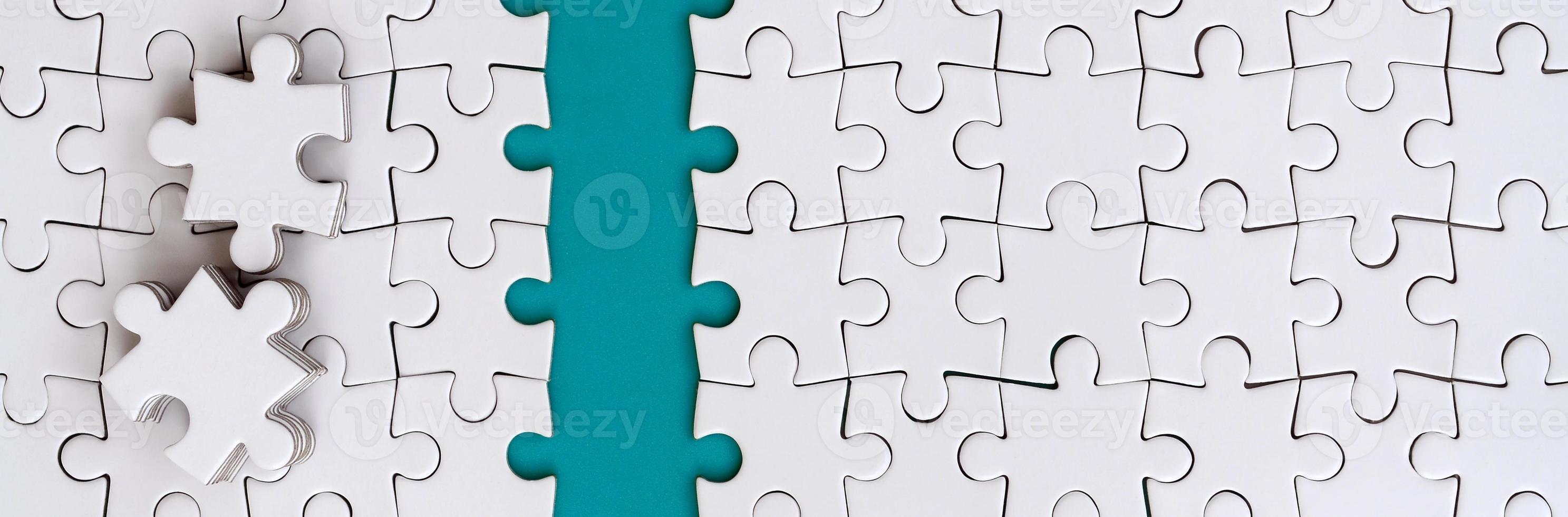 The blue path is laid on the platform of a white folded jigsaw puzzle. The missing elements of the puzzle are stacked nearby. Texture image with space for text photo