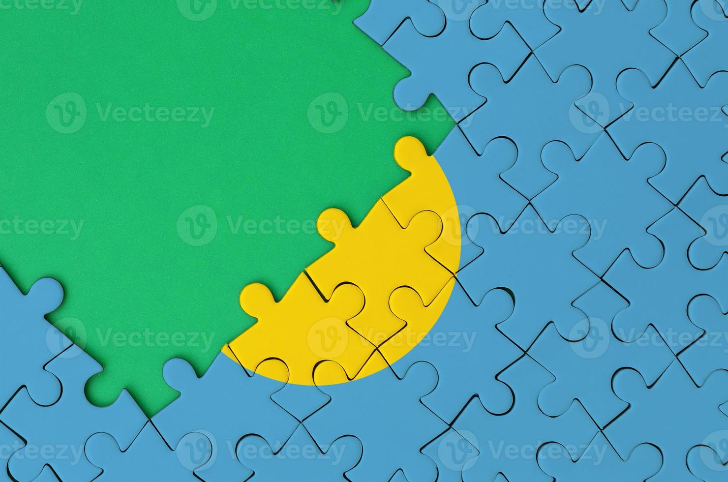 Palau flag is depicted on a completed jigsaw puzzle with free green copy space on the left side photo