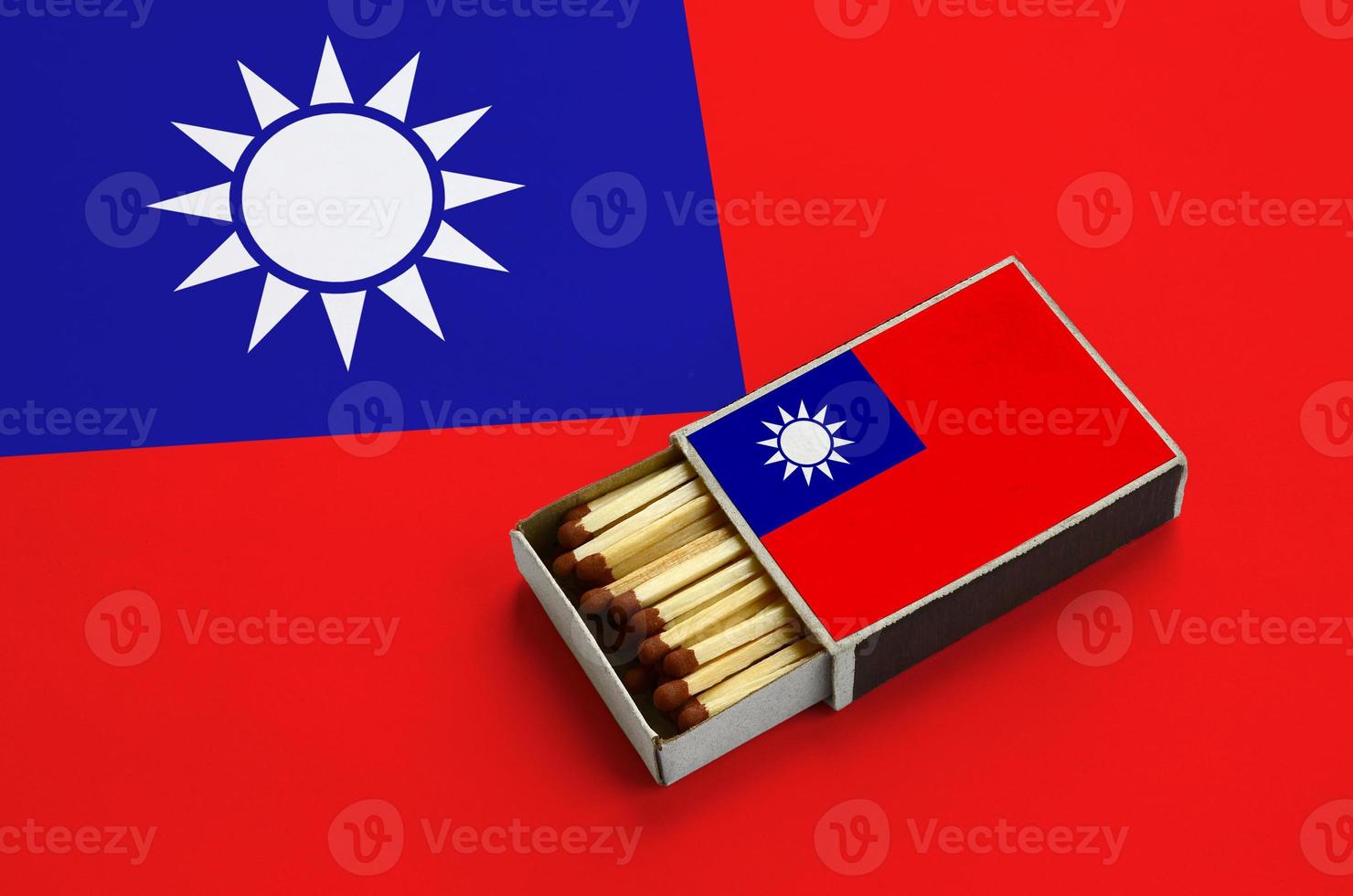 Taiwan flag is shown in an open matchbox, which is filled with matches and lies on a large flag photo