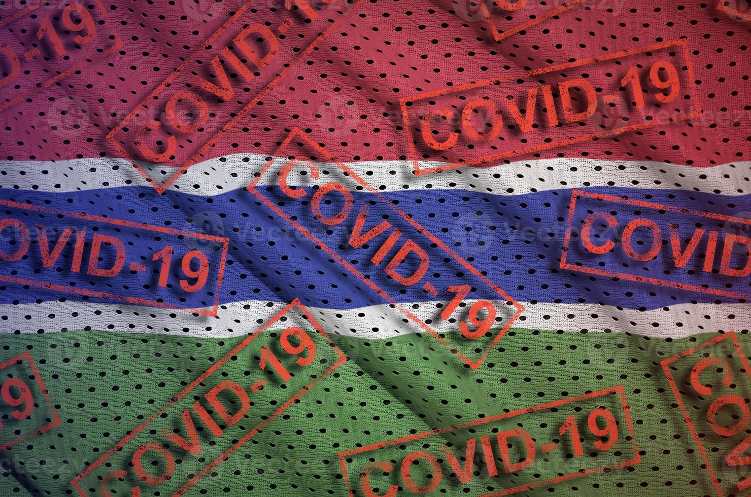 Gambia flag and many red Covid-19 stamps. Coronavirus or 2019-nCov virus concept photo