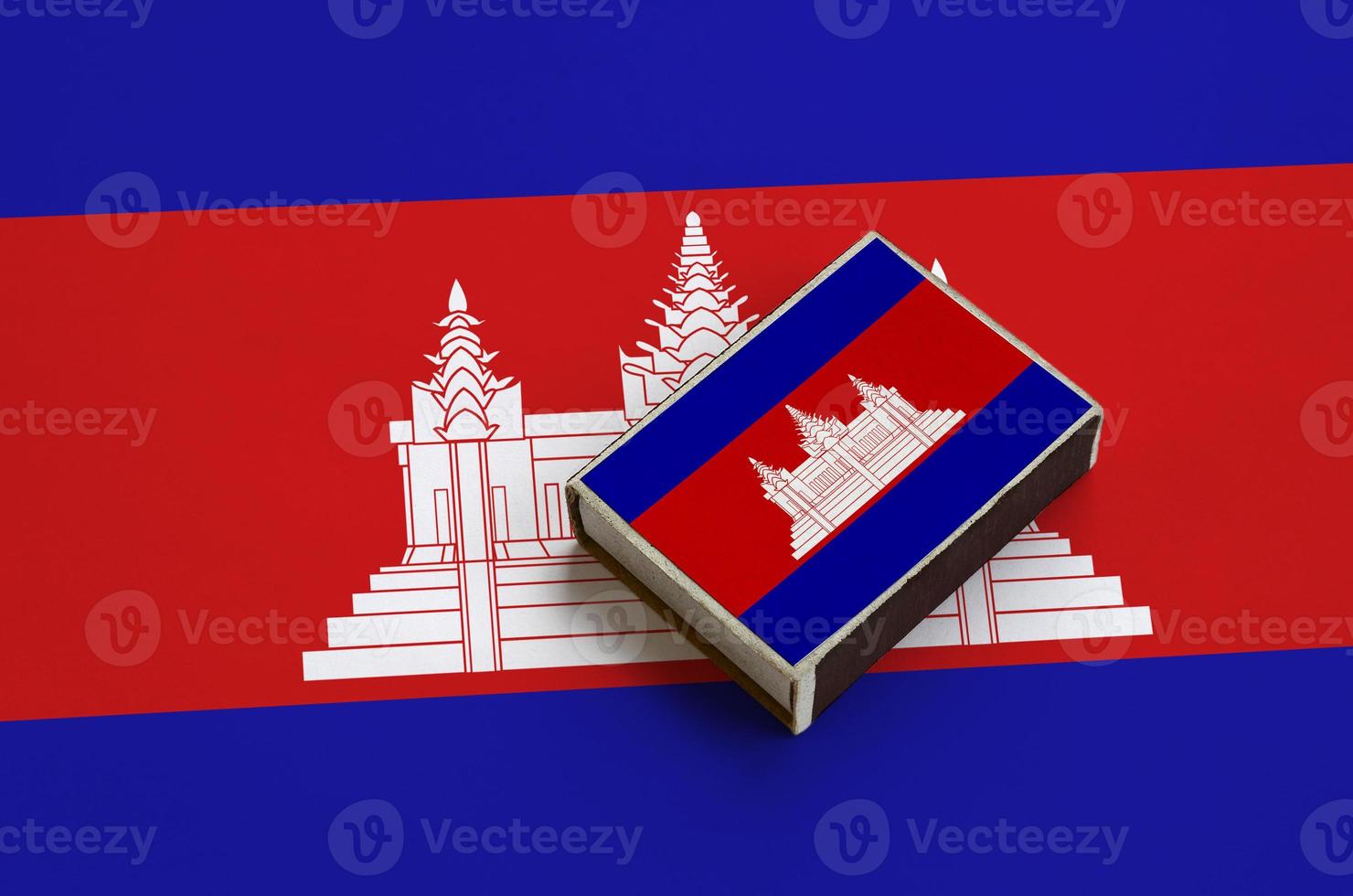 Cambodia flag is pictured on a matchbox that lies on a large flag photo