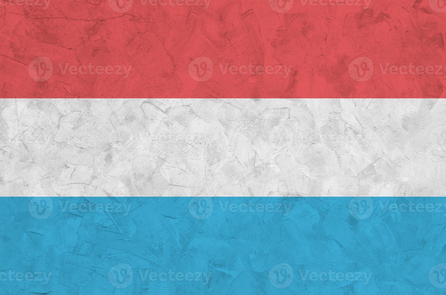Luxembourg flag depicted in bright paint colors on old relief plastering wall. Textured banner on rough background photo