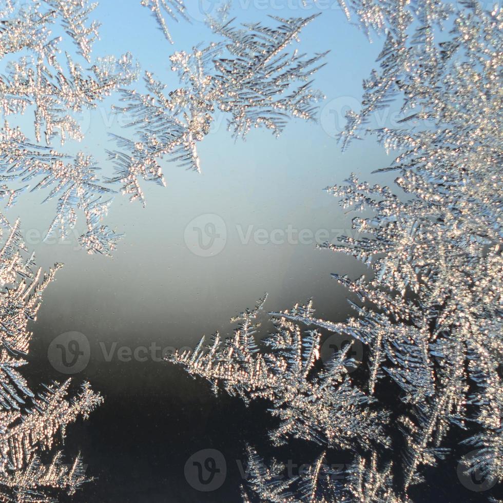 Snowflakes frost rime macro on window glass pane photo