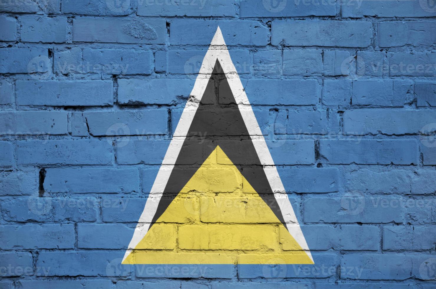 Saint Lucia flag is painted onto an old brick wall photo