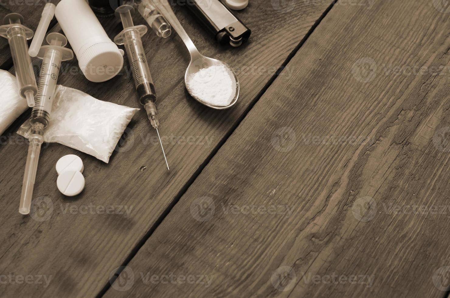 A lot of narcotic substances and devices for the preparation of drugs lie on an old wooden table photo