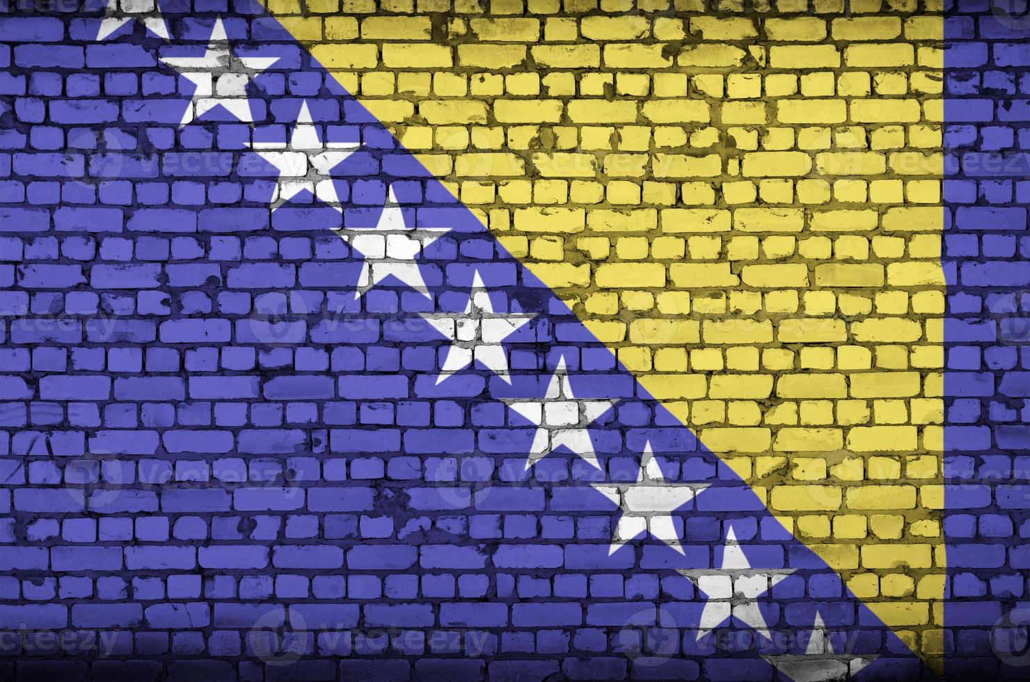 Bosnia and Herzegovina flag is painted onto an old brick wall photo